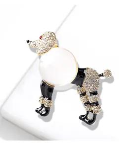Détail d'une broche caniche vintage avec cristaux brillants et perle laiteuse.
