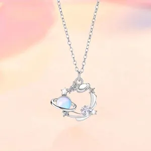 Gedetailleerde close-up van een zilveren planeetketting met een blauwe opaalsteen.