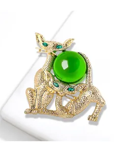 Détail d'une broche chat vintage ton or avec cabochon en verre vert translucide