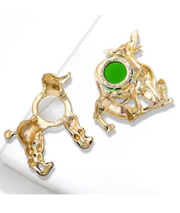 Vue arrière détaillée de broches vintage en or en forme de caniche et chat avec verre vert