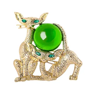 Broche chat vintage en métal doré avec une sphère en verre vert translucide et yeux
