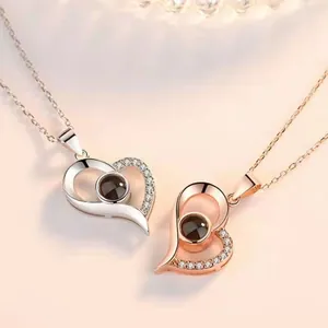 Detailed view of silver and rose gold heart projection necklaces with micro-paved stones