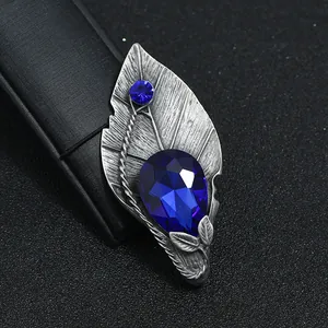 Detail van vintage bladbroche met grote blauwe edelsteen en antiek zilveren afwerking