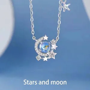 Gedetailleerde macro-weergave van zilveren ketting met blauwe maansteen en sterren.
