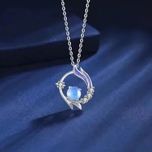 Detailopname van elegante zilveren vissenstaart hanger met blauwe edelsteen