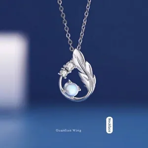 Detailopname van de zilveren vogelvleugelketting met maansteen en kleine steentjes.