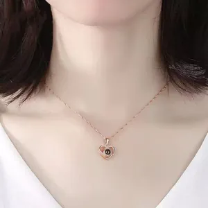 Close-up detail of a rose gold heart projection necklace worn on a female model's neck