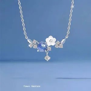 Gedetailleerd overzicht van zilveren bloemenketting met blauw kristal en witte bladen