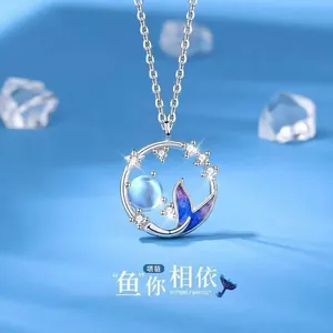 Detailopname van zilveren zeemeermin staart ketting met blauwe maansteen en zirconia.