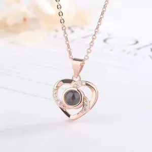 Close-up of rose gold heart projection necklace with sparkling crystal accents