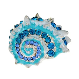Gedetailleerde macro-opname van een emaille zeeschelp broche met blauwe kristallen