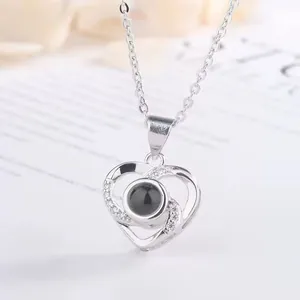Detailed view of a silver heart projection necklace with 100 languages I love you stone