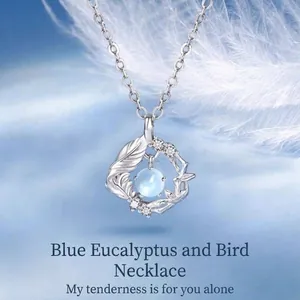 Elegante zilverkleurige ketting met vogel en blad hanger en ronde blauwe steen