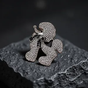 Elegante poedelbrochespeld met glinsterende witte strass-steentjes op zwarte rotsen