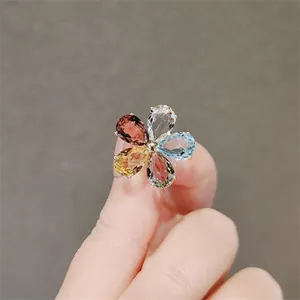 Detalle de un broche con forma de flor brillante y pétalos de cristal de colores.