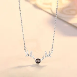 Macro view of antler pendant necklace with central projection stone and crystal accents