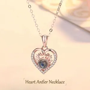 Close-up of rose gold heart necklace with reindeer antlers and projection stone