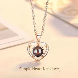 Macro detail of rose gold heart-shaped pendant necklace featuring a central projection stone