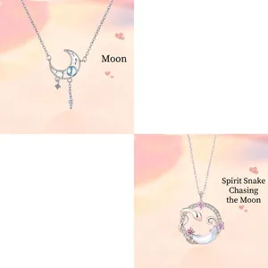 Macro view of silver moonstone necklaces featuring celestial moon and snake motifs with pink gems