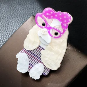 Vue détaillée d'une broche chien en acrylique faite main avec lunettes et bandeau