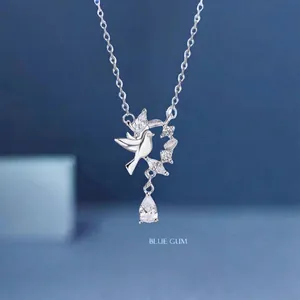 Silver dove and wheat ear necklace detail featuring a dangling teardrop shaped crystal