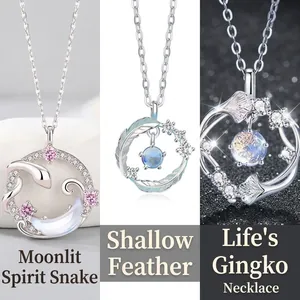 Detailed view of three elegant necklaces featuring snake, feather and ginkgo leaf designs.