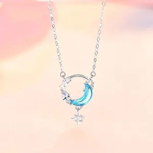 Elegante zilveren ster- en maanketting met een lichtblauwe doorschijnende halve maan