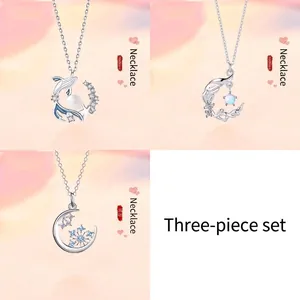 Set of three silver necklaces featuring whale, moonlight, and snowflake pendants