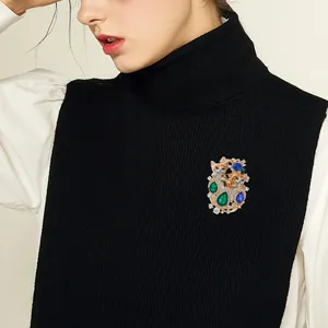 Elegant vintage rhinestone double cat brooch displayed on a black turtleneck sweater