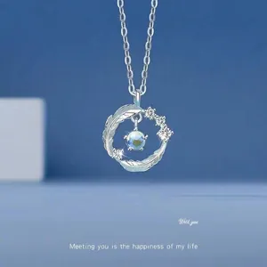 Detail of silver feather pendant necklace with a brilliant blue iridescent stone