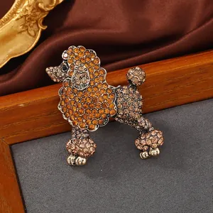Élégante broche caniche avec strass ambre et champagne étincelants sur métal doré.
