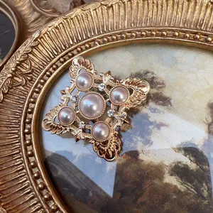 Macro detail of vintage baroque brooch with pearls and crystals in gold frame art