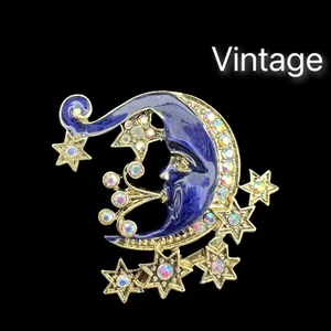 Detailansicht einer Vintage-Brosche aus blauem Emaille mit Mond, Sternen und Steinen