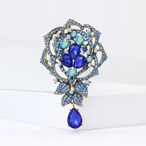 Detailed shot of a vintage style luxury blue rhinestone rose brooch with teardrop pendant
