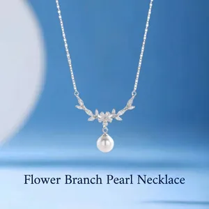 Close-up of an elegant silver necklace with a floral crystal pendant and a white pearl