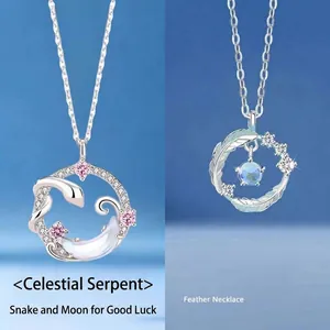 Silver pendant necklaces with snake moon and feather designs on blue background