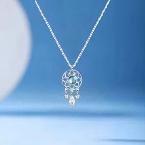 Detailed shot of a silver dreamcatcher necklace with a blue stone and crystal charms