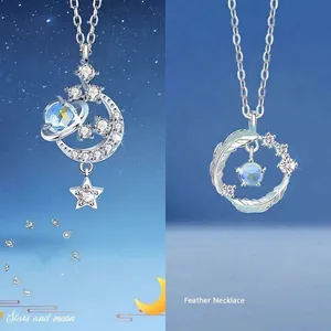 Detail van een zilveren ster- en maanketting naast een blauwe steen veren ketting