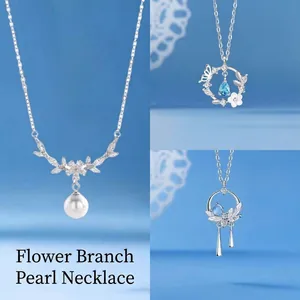 Elegant silver pearl and gemstone necklace set on a serene blue background.