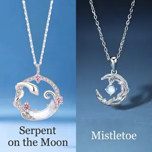 Elegante zilveren slangenring en halve maan hanger ketting set op blauwe achtergrond