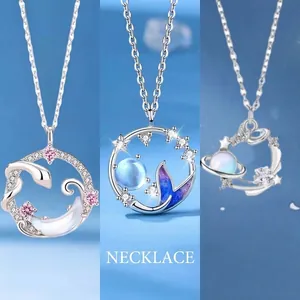 Collection of silver pendant necklaces with snake moon, mermaid tail, and planet motifs.