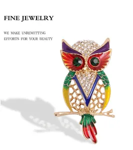 Macro-opname van een kleurrijke uil-broche in email met sprankelende strass-accenten