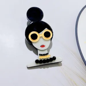 Gros plan détaillé d'une broche élégante en acrylique avec une fille portant des lunettes jaunes