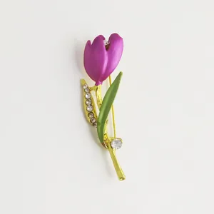 Detailed view of a purple tulip brooch with green leaves and sparkling rhinestones
