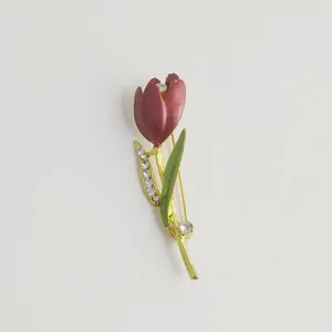 Detailed view of an elegant tulip brooch with red enamel and shimmering crystal rhinestones