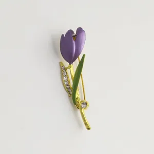 Detailed view of purple tulip enamel brooch with rhinestones on golden stem.