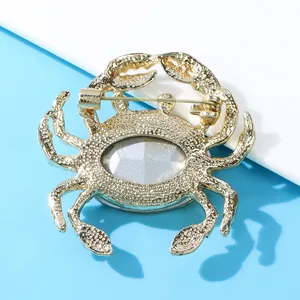 Close-up back view of gold crab brooch showing metal texture and safety pin clasp