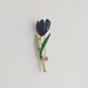 Detail of elegant tulip brooch with blue enamel and sparkling crystal accents on white.