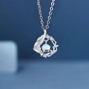 Elegante zilveren bladketting met lichtblauwe edelsteen hanger op blauwe achtergrond