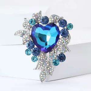 Nahaufnahme einer luxuriösen silberfarbenen Herzbrosche mit strahlend blauen Kristallen